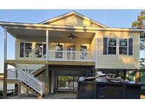 Coastal home featuring a charming covered porch and a convenient covered carport below the raised structure at 605 15Th Ave. S, North Myrtle Beach, SC 29582