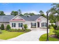 Charming one-story brick home featuring a well-manicured lawn, black shutters, and a cozy, inviting entrance at 870 Monterrosa Dr., Myrtle Beach, SC 29572
