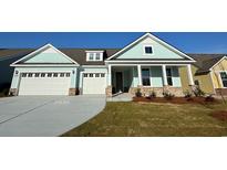 Charming home featuring an attached two-car garage, landscaped yard, and welcoming front porch at 912 Lady Bird Way, North Myrtle Beach, SC 29582