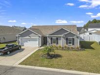 Charming single-story home with a well-maintained lawn, attached garage, and classic gray siding at 140 Golden Bear Circle, Longs, SC 29568