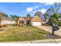 Charming single-story brick home with a well-manicured lawn and two-car garage at 329 Camden Circle, Pawleys Island, SC 29585