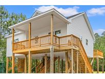 Stunning two-story beach house on stilts with a spacious covered porch and beautiful wood and white finishes at 3566 Steamer Trace Rd., Conway, SC 29527
