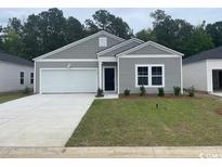 Charming single-story home featuring a two-car garage, gray siding, and well-maintained landscaping at 358 Ladyfish Loop, Sunset Beach, NC 28468