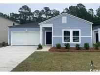 Charming single-story home featuring light blue siding, an attached garage, and a well-manicured lawn at 366 Ladyfish Loop, Sunset Beach, NC 28468