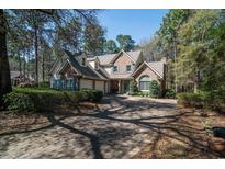 Charming brick home with blue shutters and a brick driveway surrounded by lush trees at 38 Saint Annes Pl., Pawleys Island, SC 29585