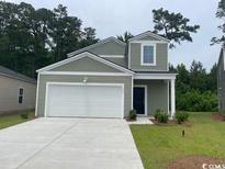 Charming home with a two-car garage, green grass, and nice curb appeal at 390 Ladyfish Loop, Sunset Beach, NC 28468