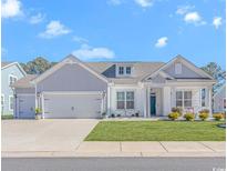 Charming single-story home with a two-car garage, manicured lawn, and inviting front porch at 746 Hickman Dr., Surfside Beach, SC 29575