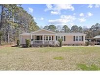 Charming single-story home with a welcoming front porch and well-maintained lawn at 107 Ben Horry Trail, Pawleys Island, SC 29585