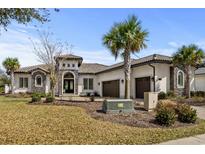 Elegant stucco home with a tile roof, stone accents, and a well-manicured front yard at 1549 Casita Ln., Myrtle Beach, SC 29579