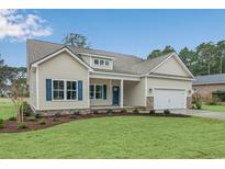 Charming single Gathering home with a manicured lawn, neutral siding, blue shutters, and an attached garage at 198 Ford Rd., Pawleys Island, SC 29585