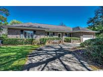 Charming single-story brick home with a well-manicured lawn and mature landscaping showcasing southern charm at 2 Chapin Circle, Myrtle Beach, SC 29572