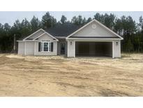 Charming single-story home with gray siding and a spacious two-car garage, set against a backdrop of lush trees at 2921 Hughes Gasque Rd., Aynor, SC 29511