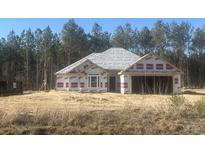 New construction home featuring a covered roof and a two-car garage, situated on a spacious lot surrounded by lush trees at 2921 Hughes Gasque Rd., Aynor, SC 29511
