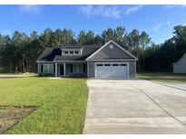 Charming single-story home with a manicured lawn and long driveway leading to a two-car garage at 2925 Hughes Gasque Rd., Aynor, SC 29511