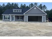 Charming single-story home with gray siding, a two-car garage, and a well-manicured lawn at 2925 Hughes Gasque Rd., Aynor, SC 29511