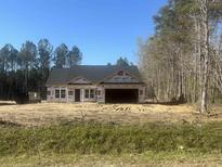 New construction home featuring a two-car garage in a wooded area at 2929 Hughes Gasque Rd., Aynor, SC 29511