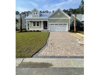 Charming single-story home with a well-manicured lawn and a brick paver driveway at 382 Waties Dr., Murrells Inlet, SC 29576