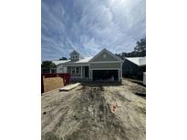Charming single-story home with a metal roof, light green siding and an attached two car garage at 382 Waties Dr., Murrells Inlet, SC 29576