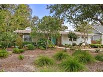Charming single-story home with a lush, landscaped front yard and a welcoming teal front door at 404 66Th Ave. N, Myrtle Beach, SC 29572