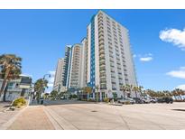 Coastal condo complex featuring multi-story buildings, palm trees, and convenient street parking at 504 N Ocean Blvd. # 401, Myrtle Beach, SC 29577
