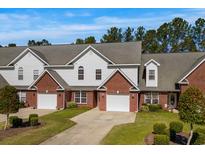 Attractive townhomes feature brick accents, attached garages, and well-maintained landscaping at 822 Foxtail Dr. # 822, Longs, SC 29568