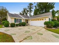 Charming single-story home with a landscaped yard and a two-car garage with decorative details at 1202 Formby Ct., Myrtle Beach, SC 29588