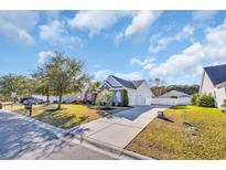 Beautiful one-story home with a manicured lawn, mature trees, and a welcoming driveway at 133 Hartwell Dr., Little River, SC 29566
