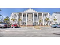 Beautiful exterior of a condo with white pillars, brick accents, and ample parking at 142 Birch N Coppice Dr. # 5, Surfside Beach, SC 29575