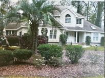 Charming two-story traditional home with a well-manicured lawn, mature trees, and beautiful landscaping at 1599 Hawthorn Dr., Pawleys Island, SC 29585