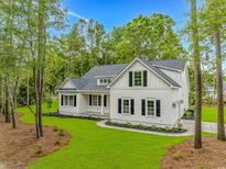 Charming two-story home with black shutters, manicured lawn and professional landscaping at 19 Coventry Pl., Pawleys Island, SC 29585