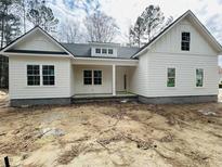 Charming single-story home with a white exterior, inviting front porch, and ample natural light at 19 Coventry Pl., Pawleys Island, SC 29585