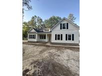 Beautiful, newly constructed white home featuring black shutters and a charming front porch at 19 Coventry Pl., Pawleys Island, SC 29585