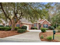 Charming brick home with lush landscaping, a circular driveway, and a two-car attached garage at 192 Berkshire Loop, Pawleys Island, SC 29585