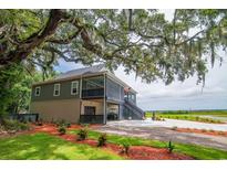 Beautiful raised home with mature trees, large yard, and ample parking space; lovely outdoor living at 224 Oak Bay Dr., Georgetown, SC 29440