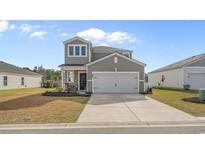 Charming two-story home with a well-manicured lawn, two car garage, and inviting front porch at 338 Hillwood Ct., Longs, SC 29568