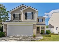 Charming two-story home with a two-car garage, neutral siding, black shutters, and a well-maintained lawn at 425 Dandelion Ln., Myrtle Beach, SC 29579