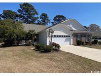 Charming single-story home with well-maintained landscaping and an attached two-car garage at 471 Deerfield Links Dr., Surfside Beach, SC 29575