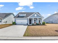 Charming single-story home with blue siding, a well-manicured lawn, and an attached garage at 5606 Whitebark Dr., Myrtle Beach, SC 29577