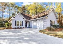 Charming single-story home with a two-car garage, manicured lawn, and lush landscaping at 75 Prestwick Dr., Pawleys Island, SC 29585