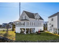 Inviting gray two-story house with a welcoming front porch and well-manicured lawn at 100 Marblehead Dr., Little River, SC 29566