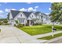 Stunning, two-story home with a lush lawn, manicured landscaping, and a concrete driveway leading to a spacious three-car garage at 1121 Glossy Ibis Dr., Conway, SC 29526