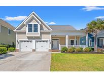 Charming home featuring a welcoming front porch, manicured lawn, and a two-car garage at 1127 East Isle Of Palms Ave., Myrtle Beach, SC 29579