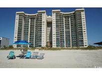 Stunning oceanfront condo building on a sandy beach, complete with beach chairs and umbrellas at 201 South Ocean Blvd. # 1209, North Myrtle Beach, SC 29582