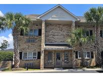 Inviting brick condominium exterior featuring palm trees and well-maintained landscaping at 218 Double Eagle Dr., Surfside Beach, SC 29575