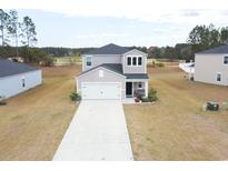 Two-story home featuring a white garage door and a well-manicured lawn at 228 Carolina Lakes Blvd., Myrtle Beach, SC 29588
