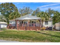 Charming single-story home with a welcoming front porch, complemented by lush landscaping and mature trees at 2405 Douglas St., North Myrtle Beach, SC 29582