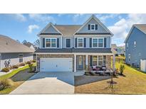 Charming two-story home featuring a brick-accented facade, two-car garage, and a beautifully landscaped front yard at 2825 Stellar Loop, Myrtle Beach, SC 29577
