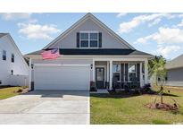 Charming single-Gathering home with a well-manicured lawn, attached garage, and inviting front porch at 294 Portofino Dr., Myrtle Beach, SC 29579