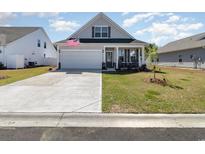 Charming single-story home featuring a lovely front porch, garage and well-manicured lawn at 294 Portofino Dr., Myrtle Beach, SC 29579