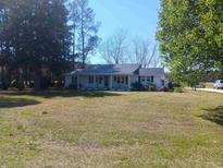 Charming single-story home with a metal roof and a spacious front yard on a sunny day at 360 Green Sea Rd., Loris, SC 29569